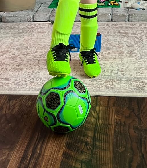 Side view of BomKinta kids soccer cleats showing ankle height and colorful design elements