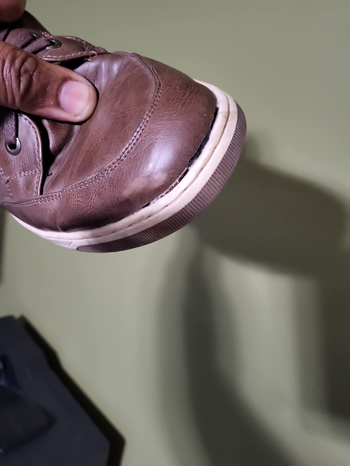 Close-up of sole separation issue showing where rubber sole detaches from synthetic upper