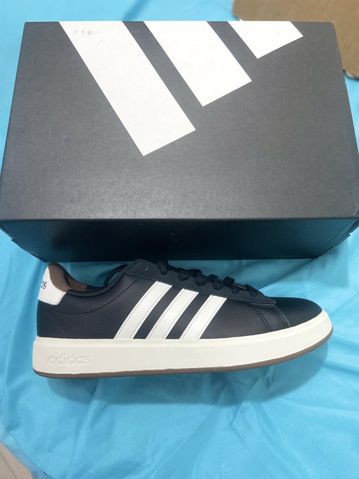 Adidas Grand Court 2.0 side profile showing three stripes design and synthetic leather upper construction