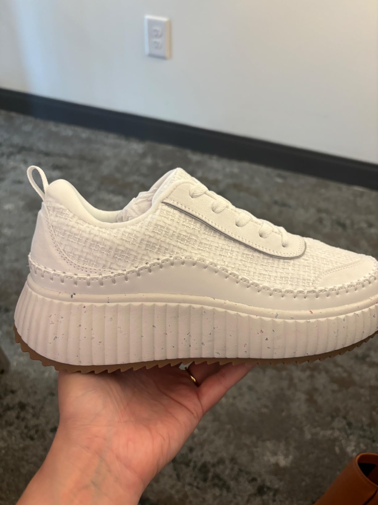 Close-up of outsole showing confetti specks—important for buyers seeking pure white