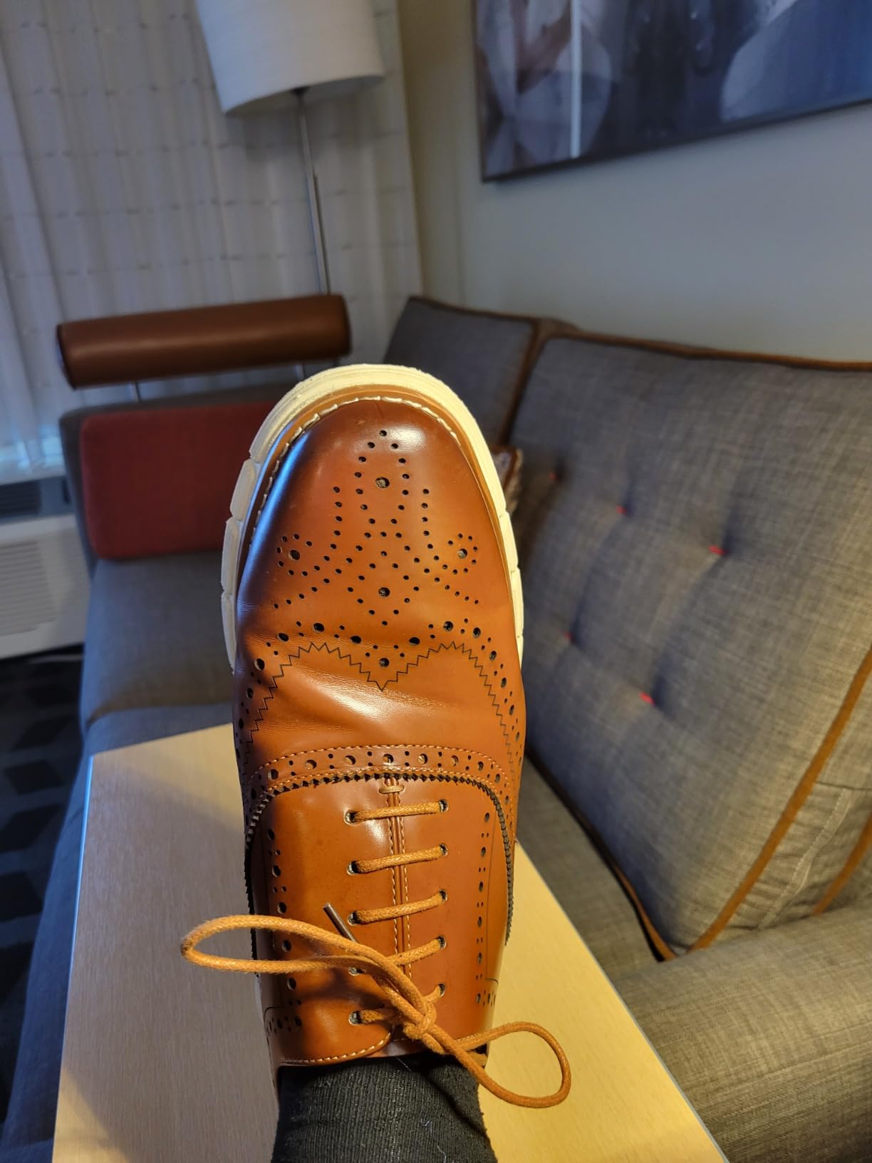 Close-up detail of Bruno Marc dress sneaker showing wingtip brogue pattern and stitching construction