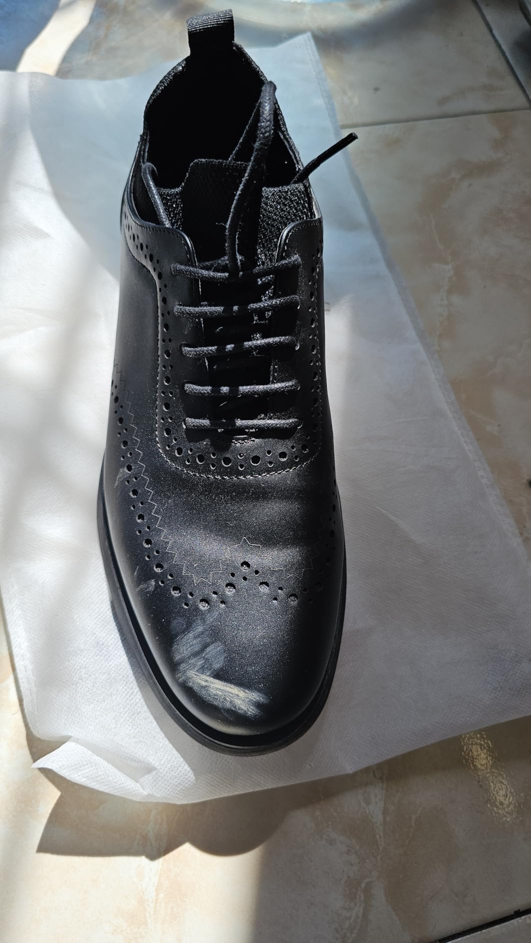 Close-up of Bruno Marc dress sneaker wingtip detailing and color contrast welt