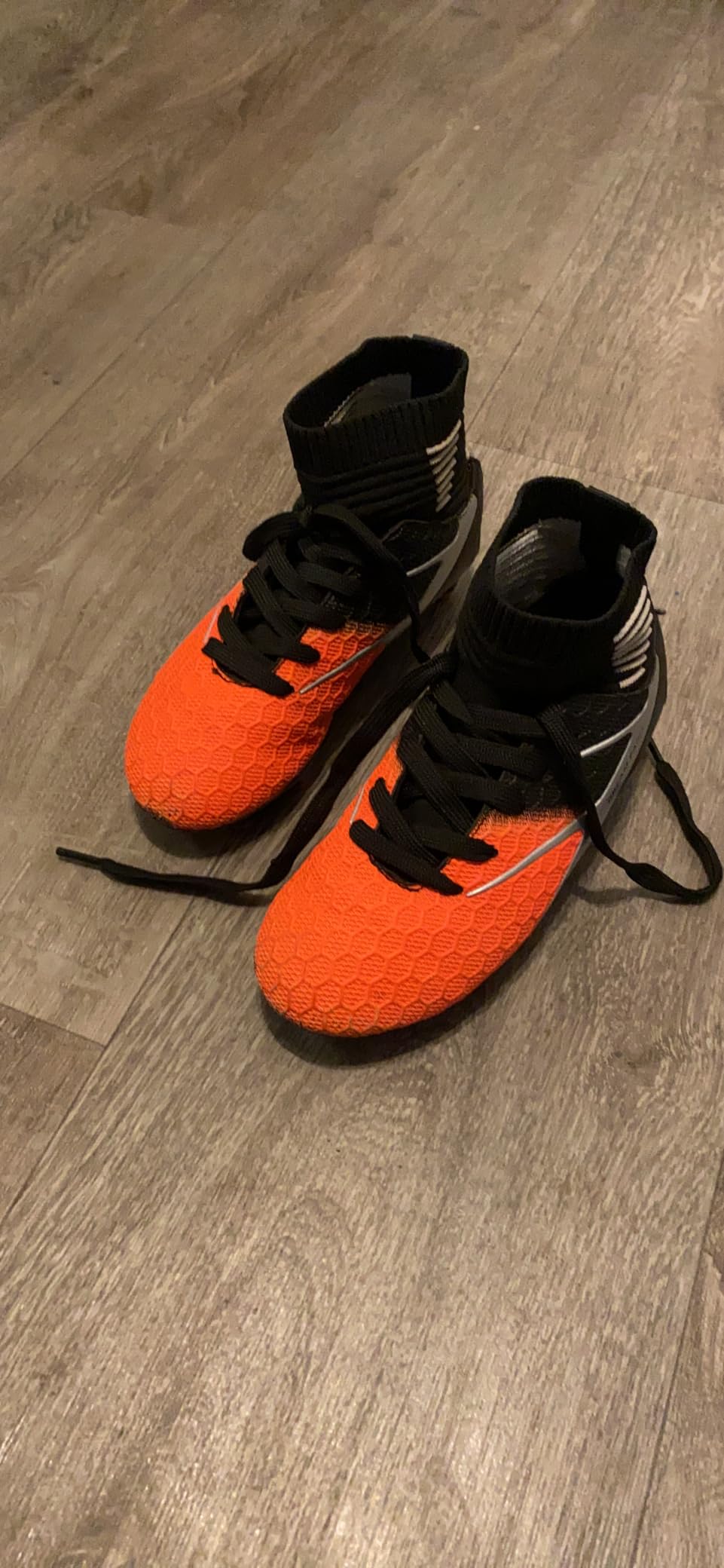Side profile of DREAM PAIRS soccer cleats showing high-top silhouette and firm ground stud pattern