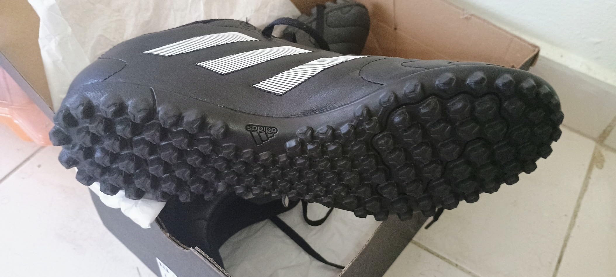 Product comparison showing adidas Goletto VIII next to packaging highlighting key features like synthetic upper and turf outsole