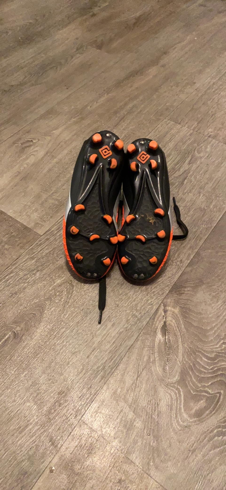 Action shot of DREAM PAIRS cleats on grass field showing traction pattern in use