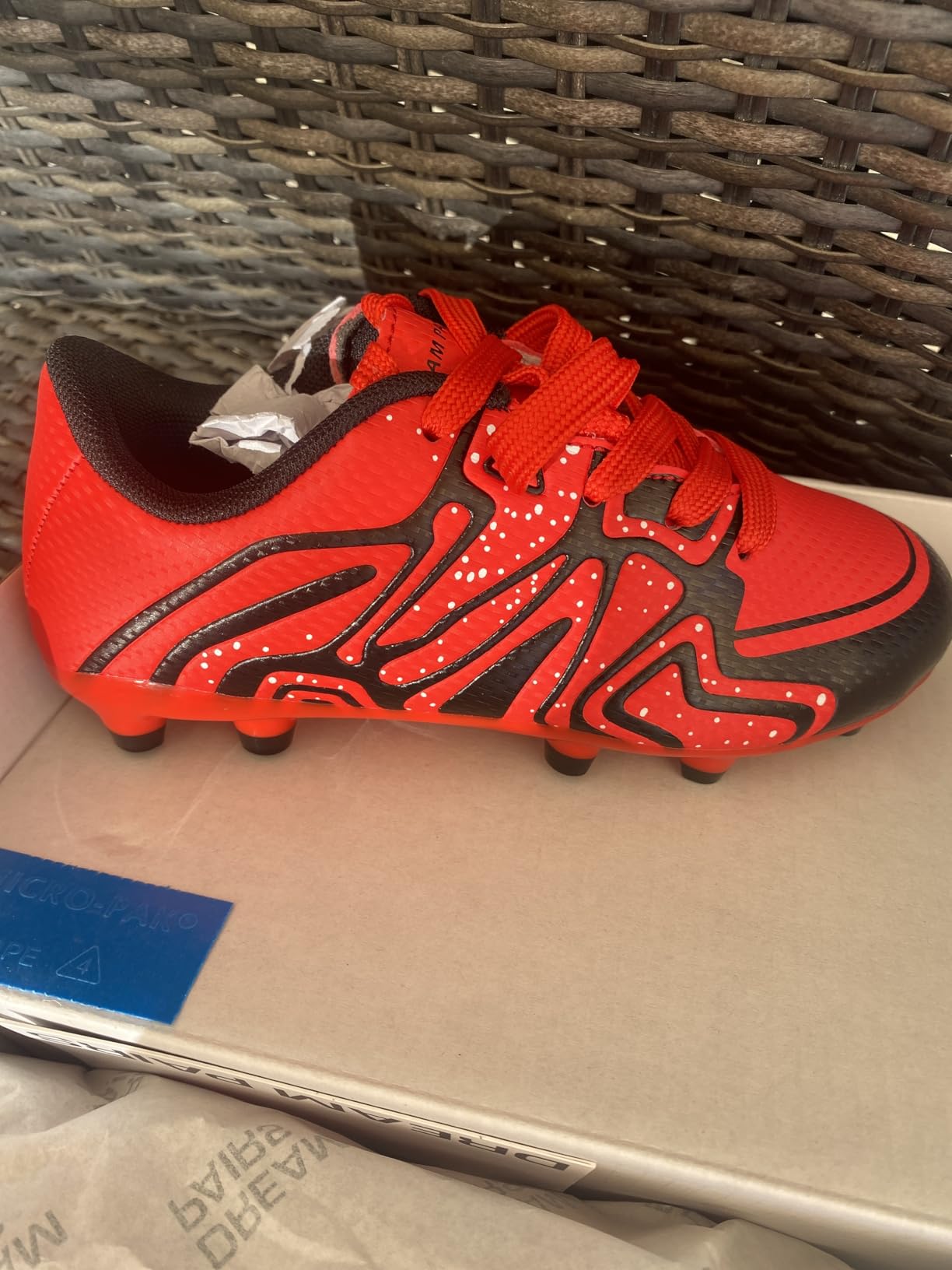 Close-up of DREAM PAIRS cleat showing molded stud configuration and sole pattern for firm ground traction