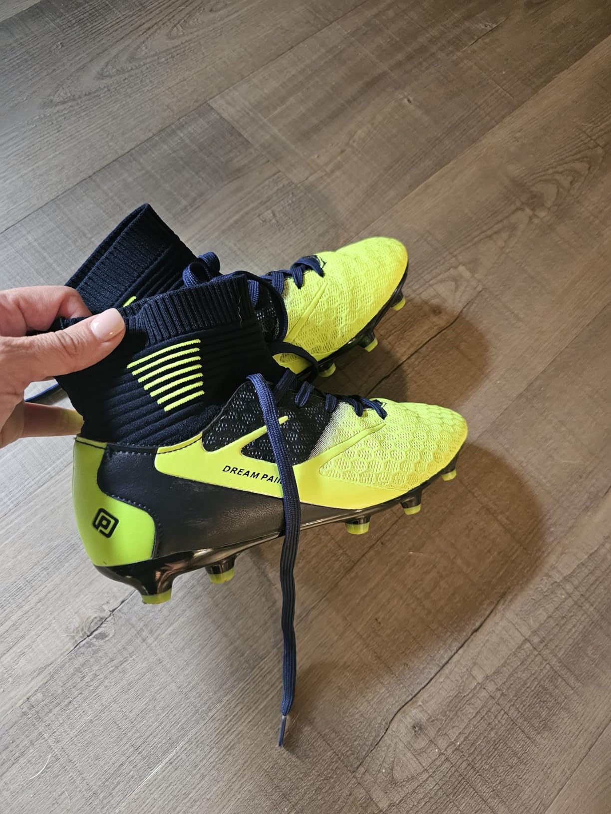 Close-up of DREAM PAIRS cleat sole showing TPU stud configuration for firm ground use