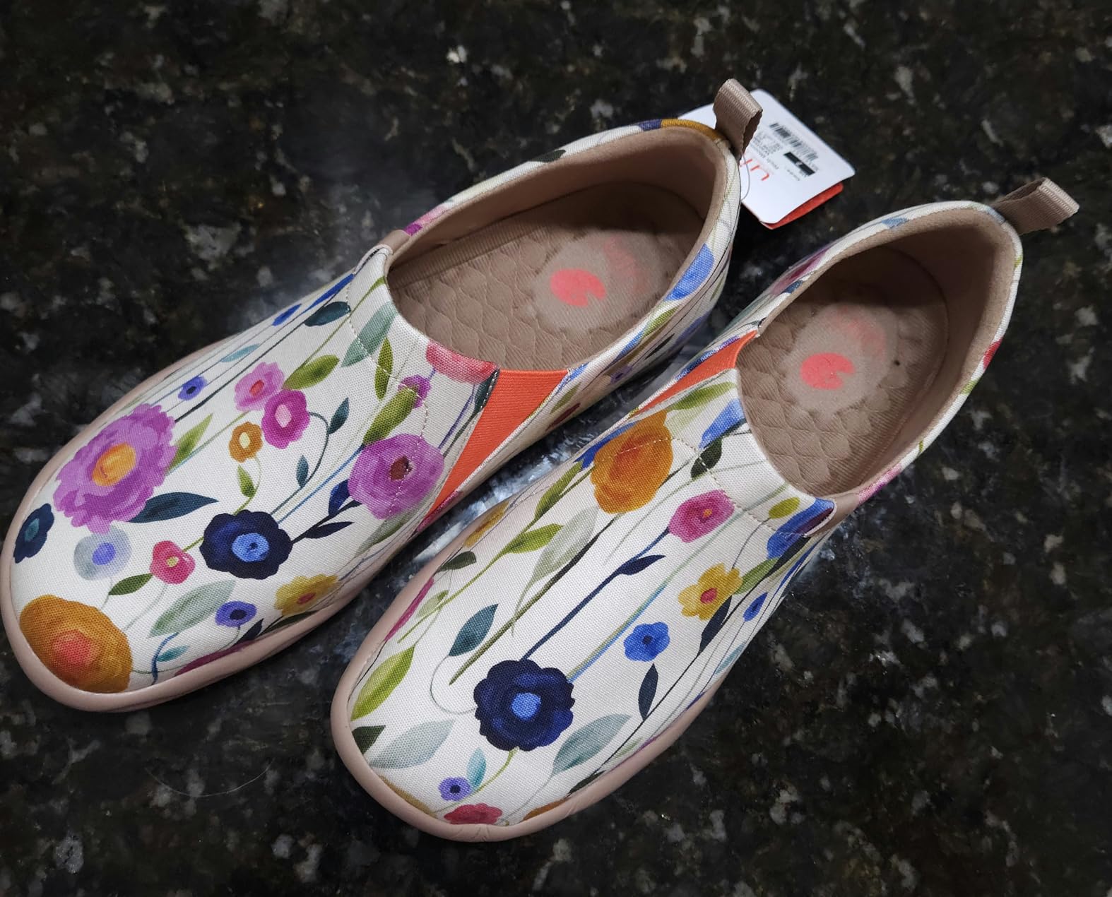 Close-up detail of UIN Blossom canvas upper showing painted floral design and slip-on construction