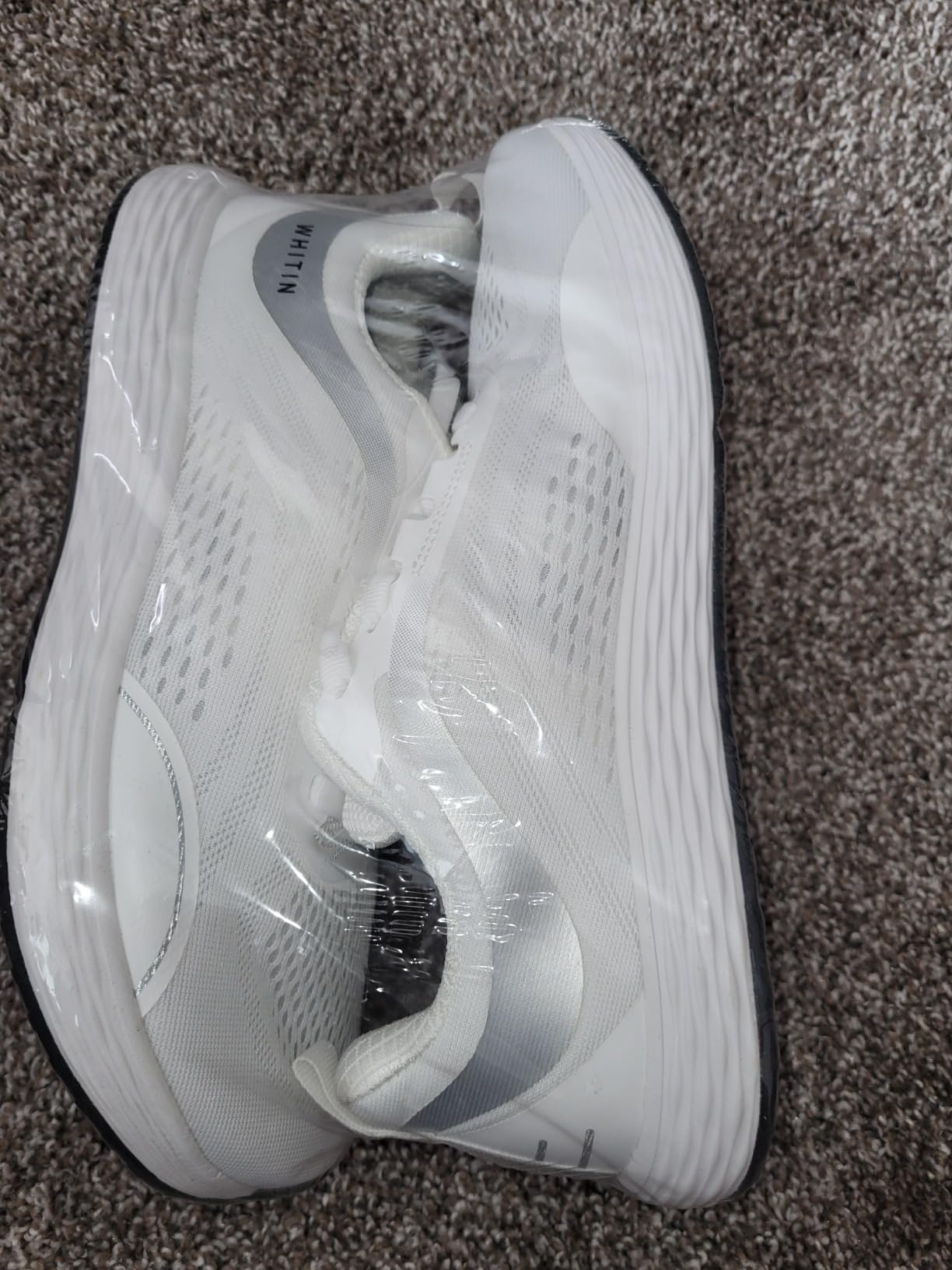 Detailed view of WHITIN shoe construction showing mesh upper and sole attachment