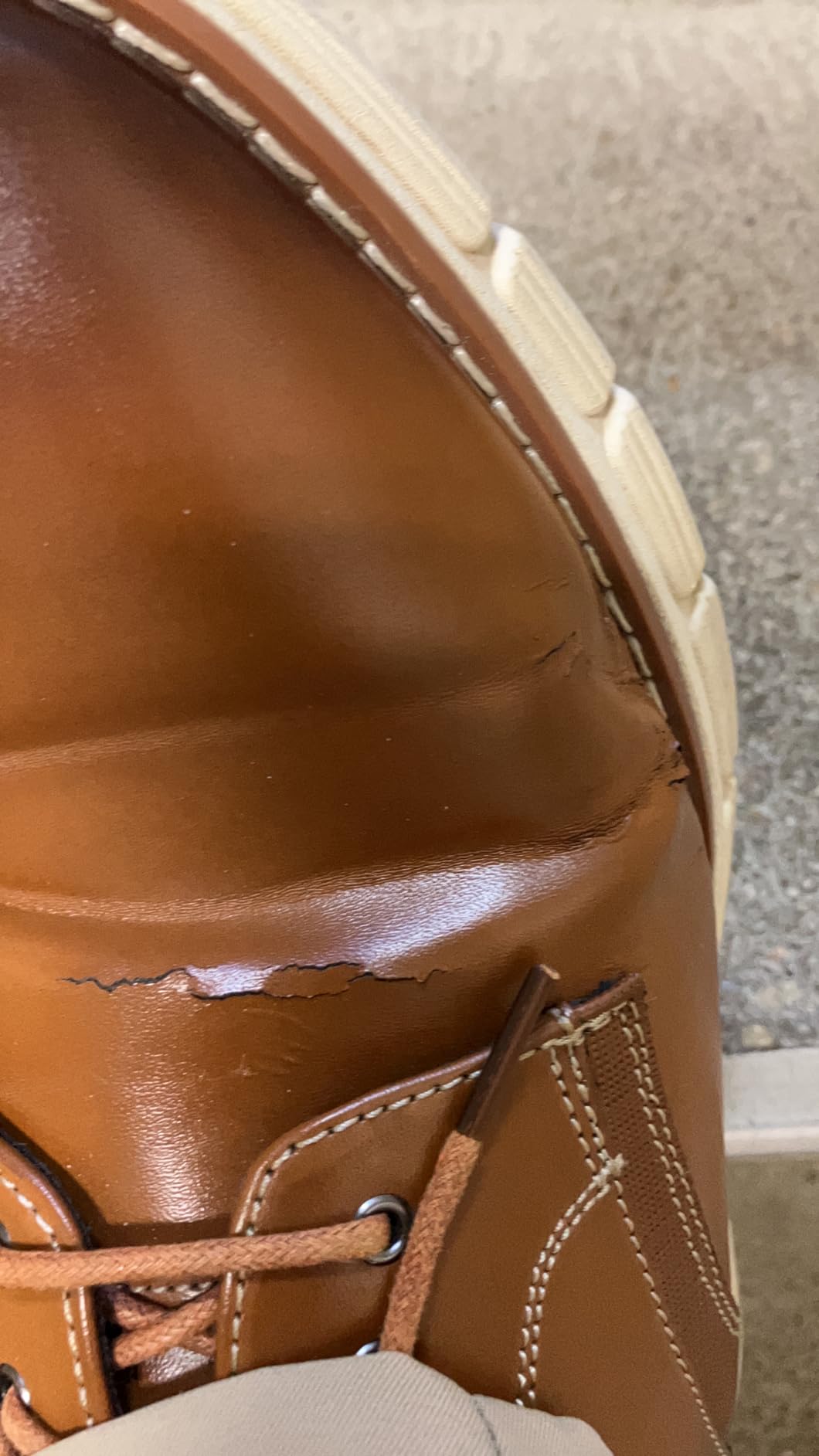 Close-up showing material wear and cracking on Bruno Marc dress sneaker after extended use