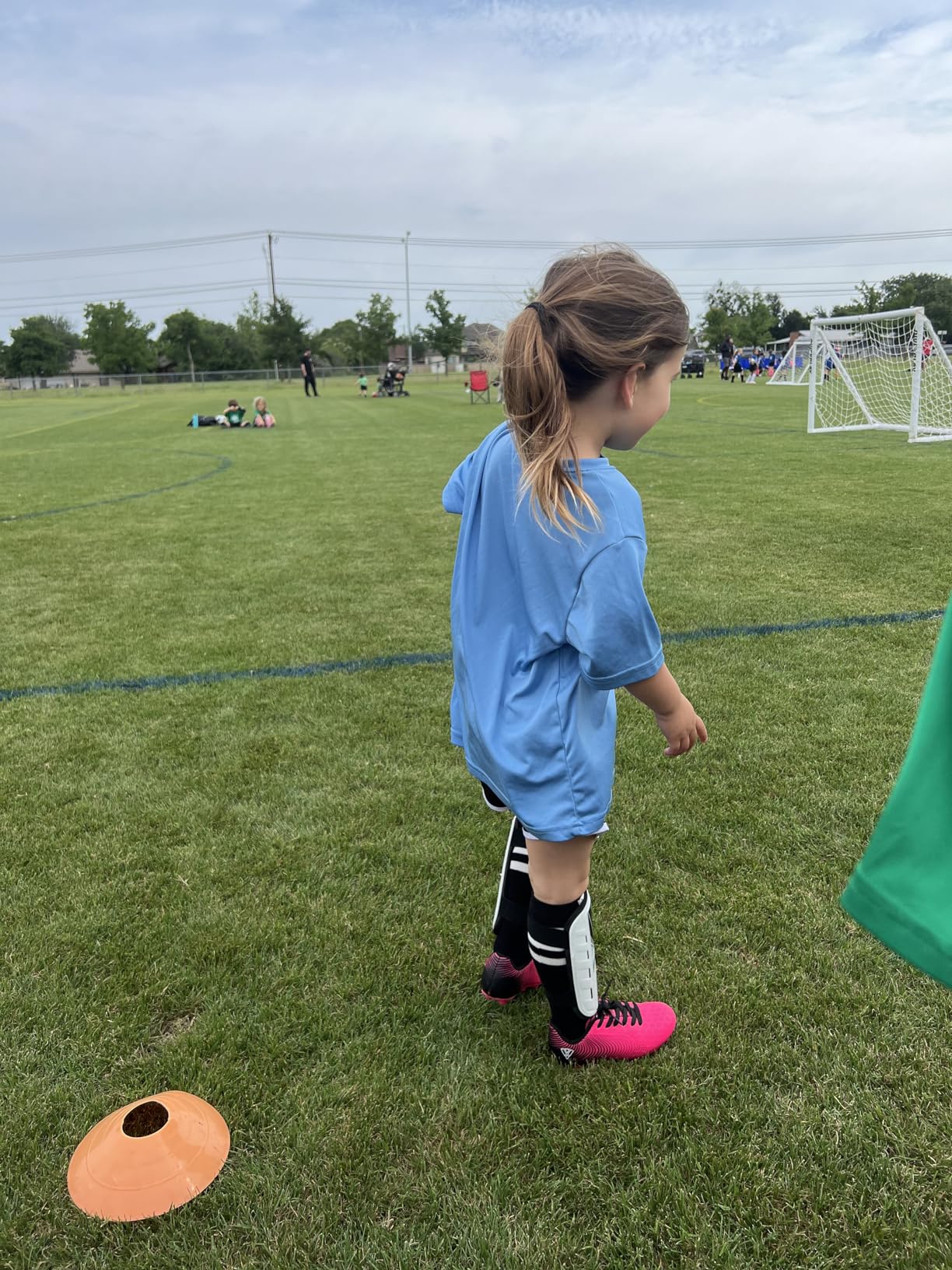Young player wearing lime green Vizari Stealth cleats during soccer practice on grass field
