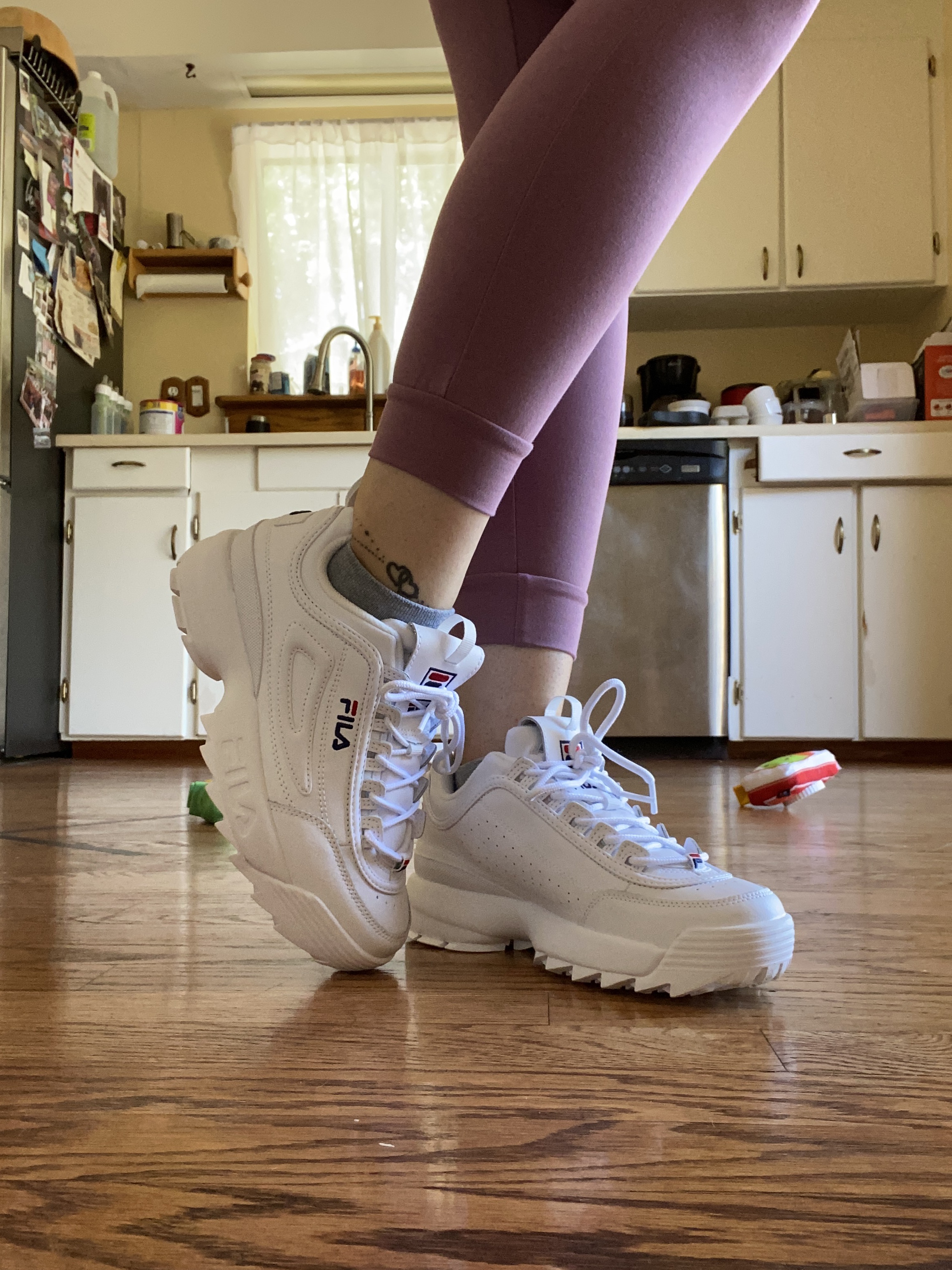 Lifestyle shot of Fila Disruptor II sneakers in casual daily wear setting