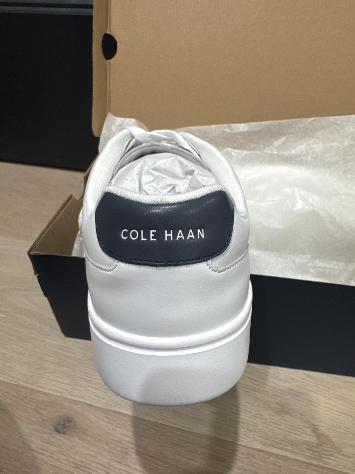 Cole Haan Grand Crosscourt sneaker side profile showing perforated leather design and court shoe silhouette