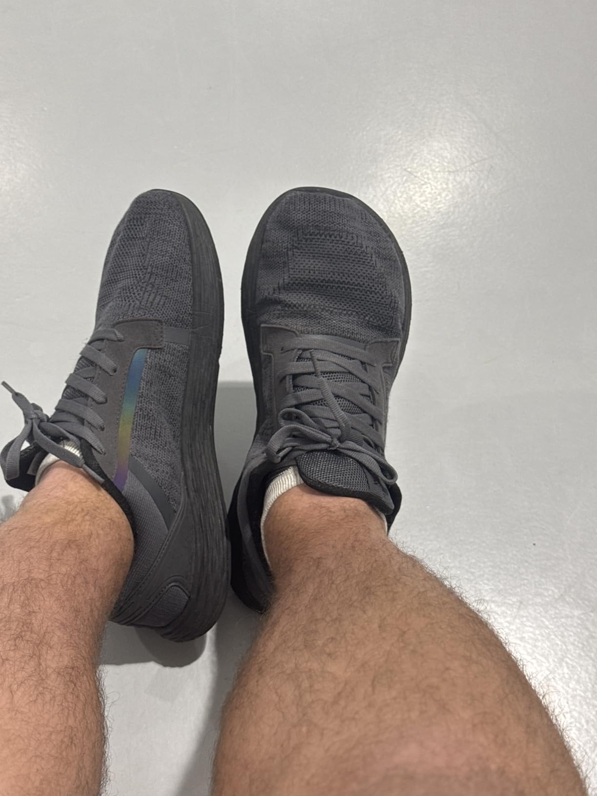 WHITIN shoes being worn during outdoor running showing reflective strip detail